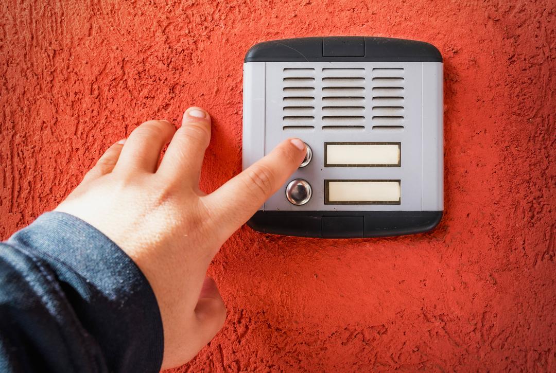 Symbolbild: Eine Hand, die an einer Türklingel klingelt. Privatadressen sollen künftig besser geschützt werden.