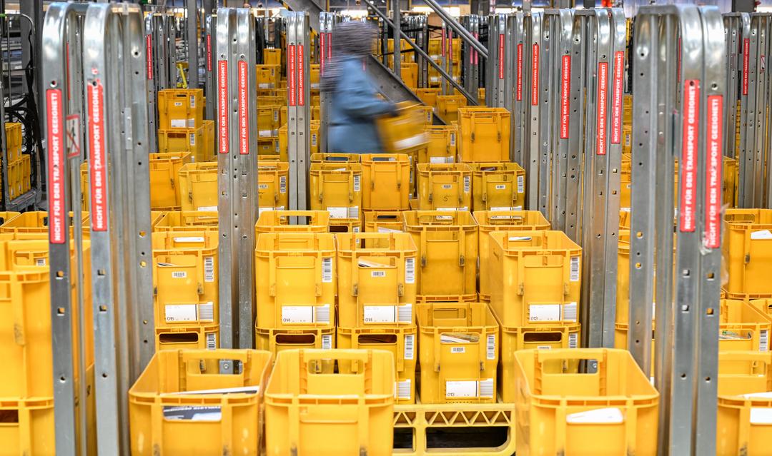 Gestapelte gelbe Sortierkisten der Deutschen Post.