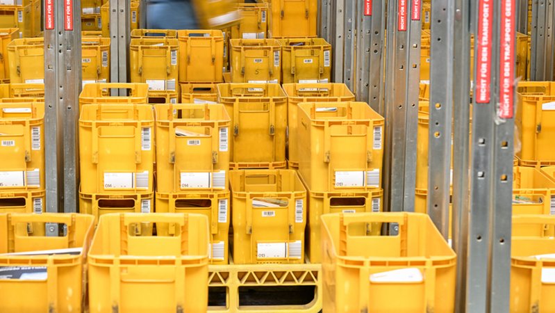Gestapelte gelbe Sortierkisten der Deutschen Post. | Bild: dpa-Bildfunk/Arne Dedert Gestapelte gelbe Sortierkisten der Deutschen Post.