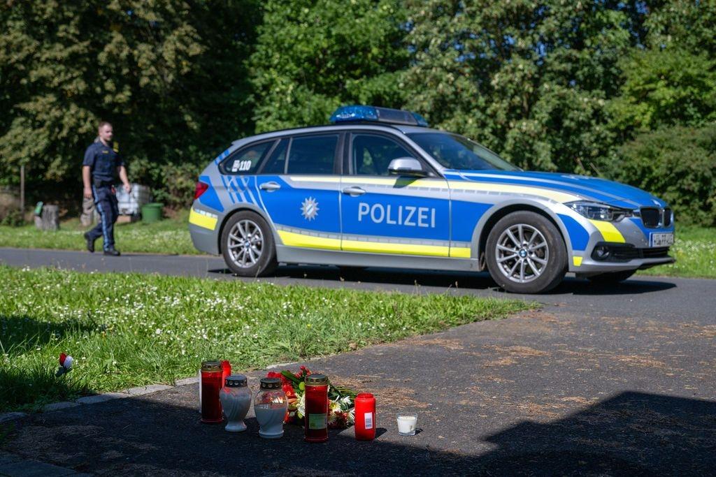 ARCHIV - 09.09.2023, Bayern, Lohr Am Main: Kerzen und Blumen sind vor einem Seiteneingang des Schulzentrums in Lohr am Main abgelegt, dahinter steht ein Polizeiwagen. (zu dpa: «Welche bedeutenden Verfahren 2024 an Bayerns Gerichten anstehen») Foto: Pia Bayer/dpa +++ dpa-Bildfunk +++