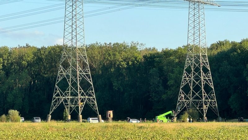 Kurz vor der Sprengung der AKW-Kühltürme in Grafenrheinfeld hatte sich ein Mann festgekettet und so die ganze Aktion verzögert. | Bild: Polizei Unterfranken Kurz vor der Sprengung der AKW-Kühltürme in Grafenrheinfeld hatte sich ein Mann festgekettet und so die ganze Aktion verzögert.