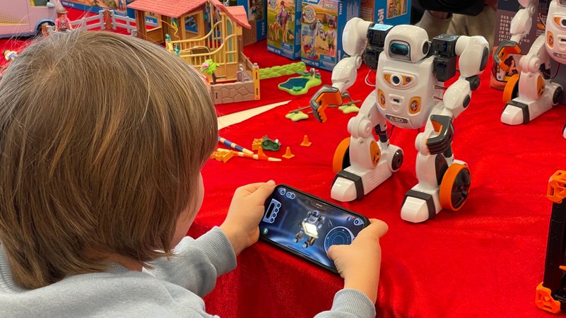 Ein Junge steuert einen Roboter mit einem Handy. | Bild: BR24/Carlo Schindhelm Ein Junge steuert einen Roboter mit einem Handy.