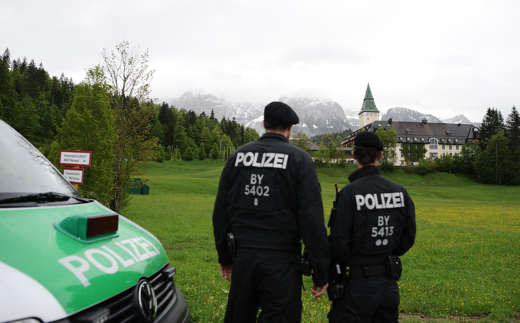Polizeistreife auf einer Wiese vor Schloss Elmau.