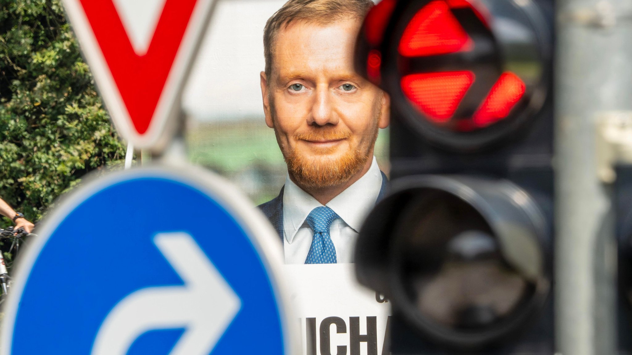 Wahlplakat von Ministerpräsident Michael Kretschmer, CDU, hinter Ampel mit rotem Rechtsabbiegerpfeil