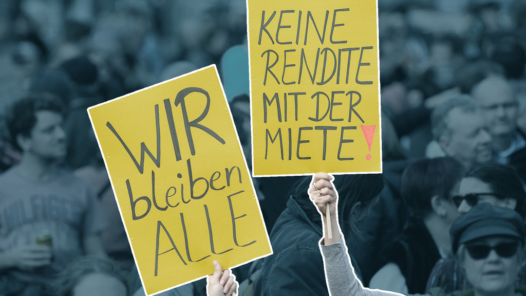 Demonstranten mit zwei Plakaten, "Wir bleiben alle" und "Keine Rendite mit der Miete"