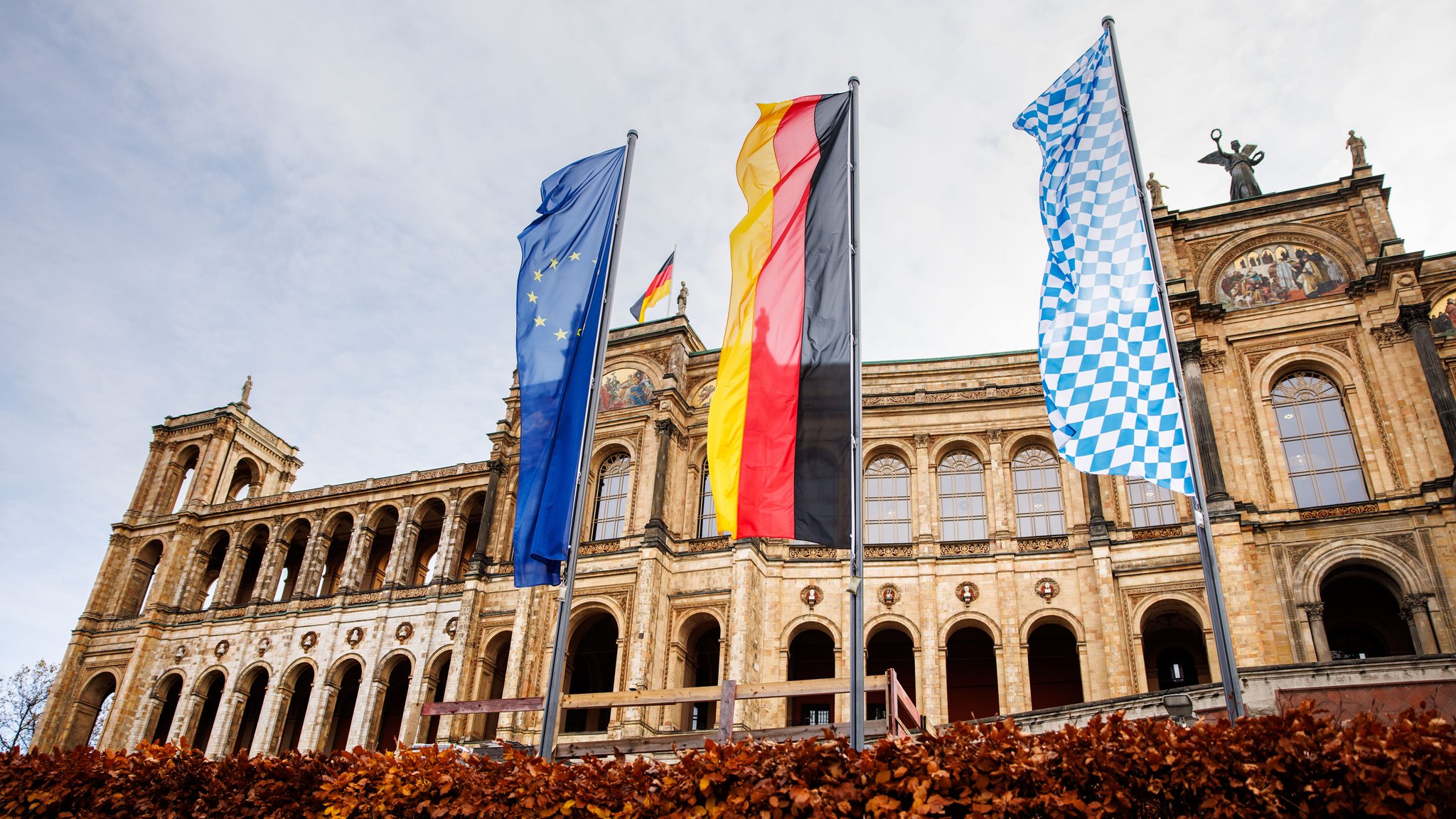 Die europäische, die deutsch und die bayerische Flagge wehen vor dem Maximilianeum, Sitz des Bayerischen Landtags, am 16.11.2023 in München (Bayern) im Wind.