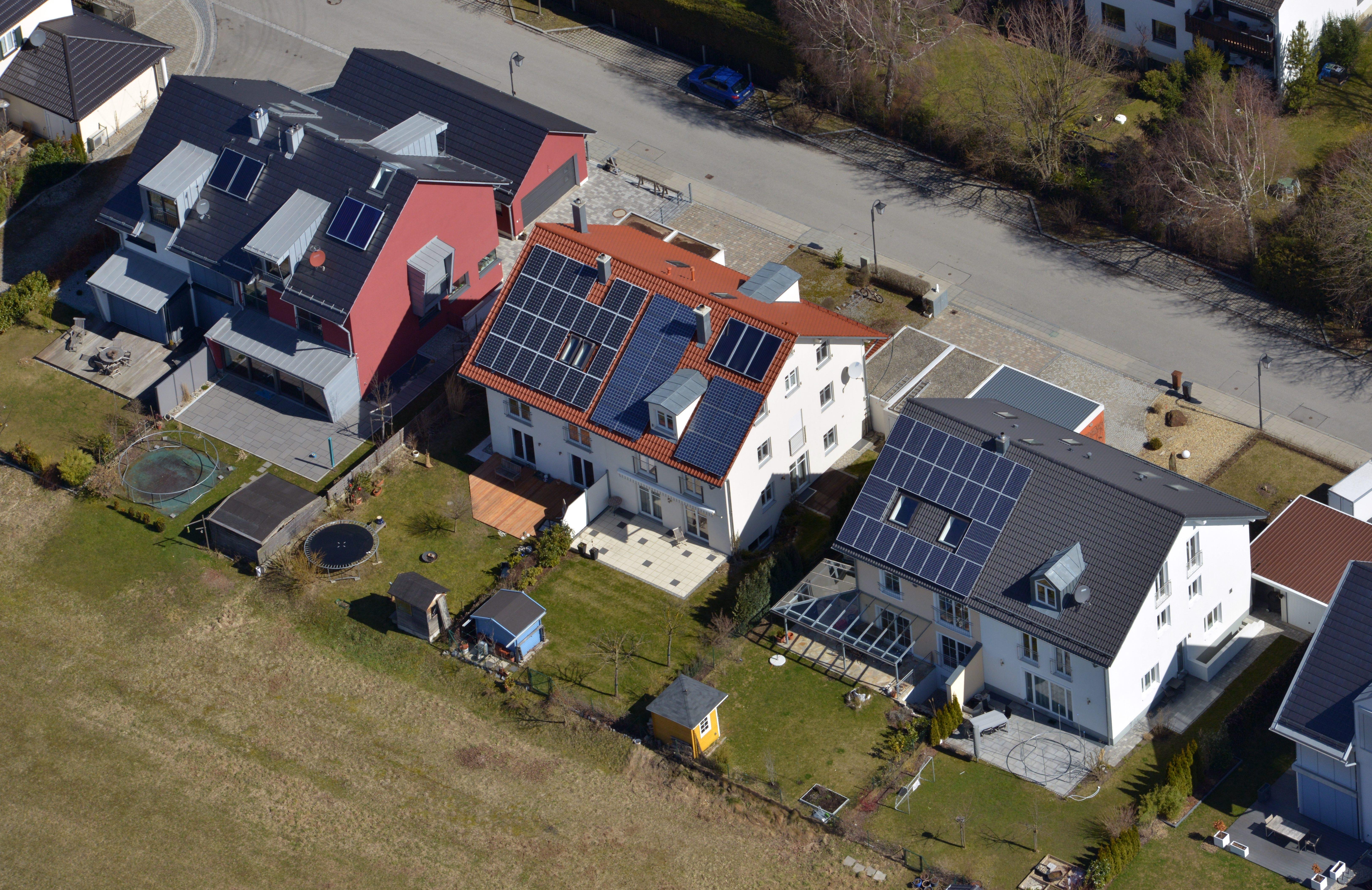 In einer Reihenhaussiedlung bei München sind mehrere Dächer mit Solarmodulen belegt. 