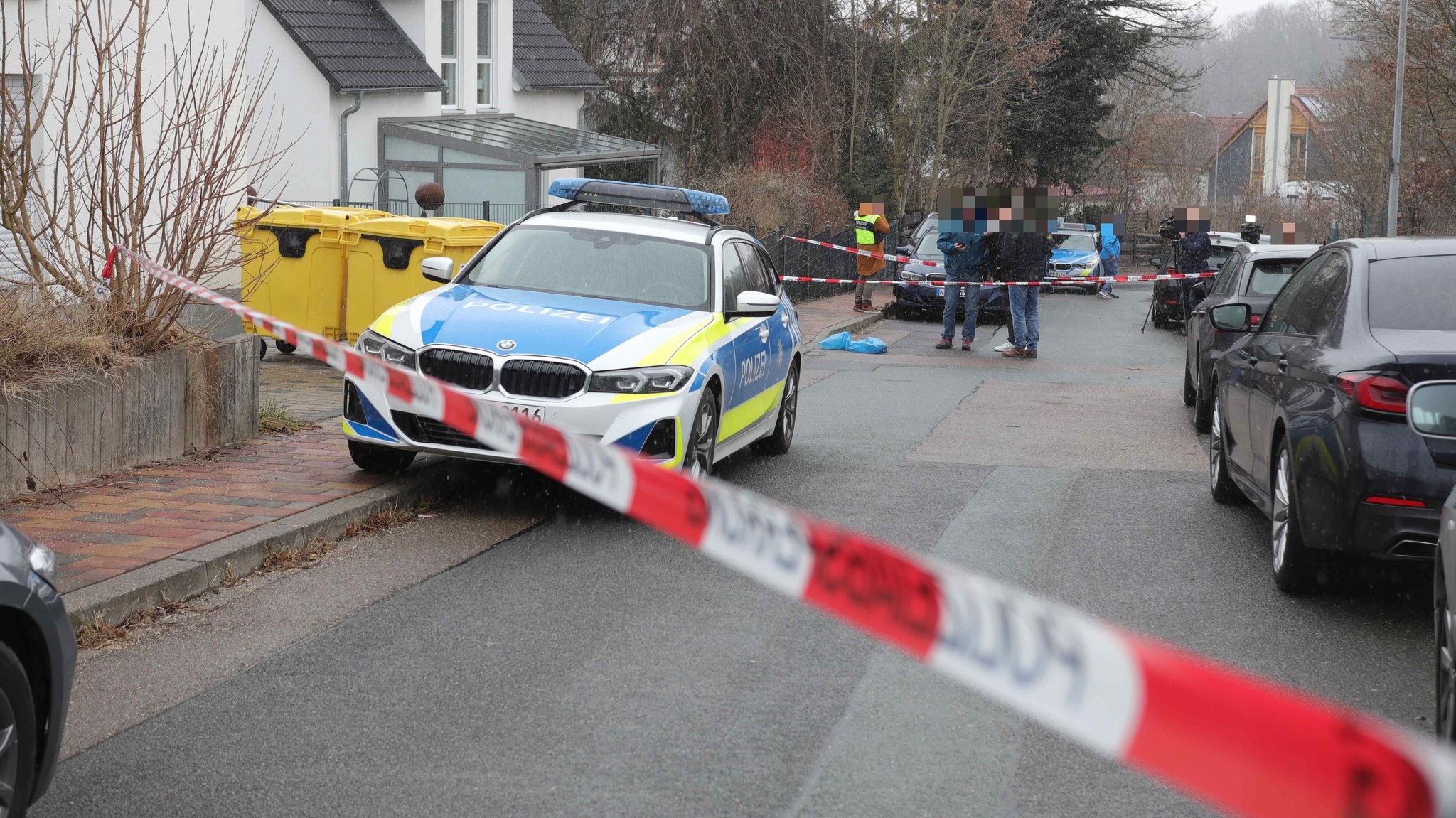 Ein Polizeiauto steht hinter Absperrband in einem Wohngebiet in Heilsbronn.