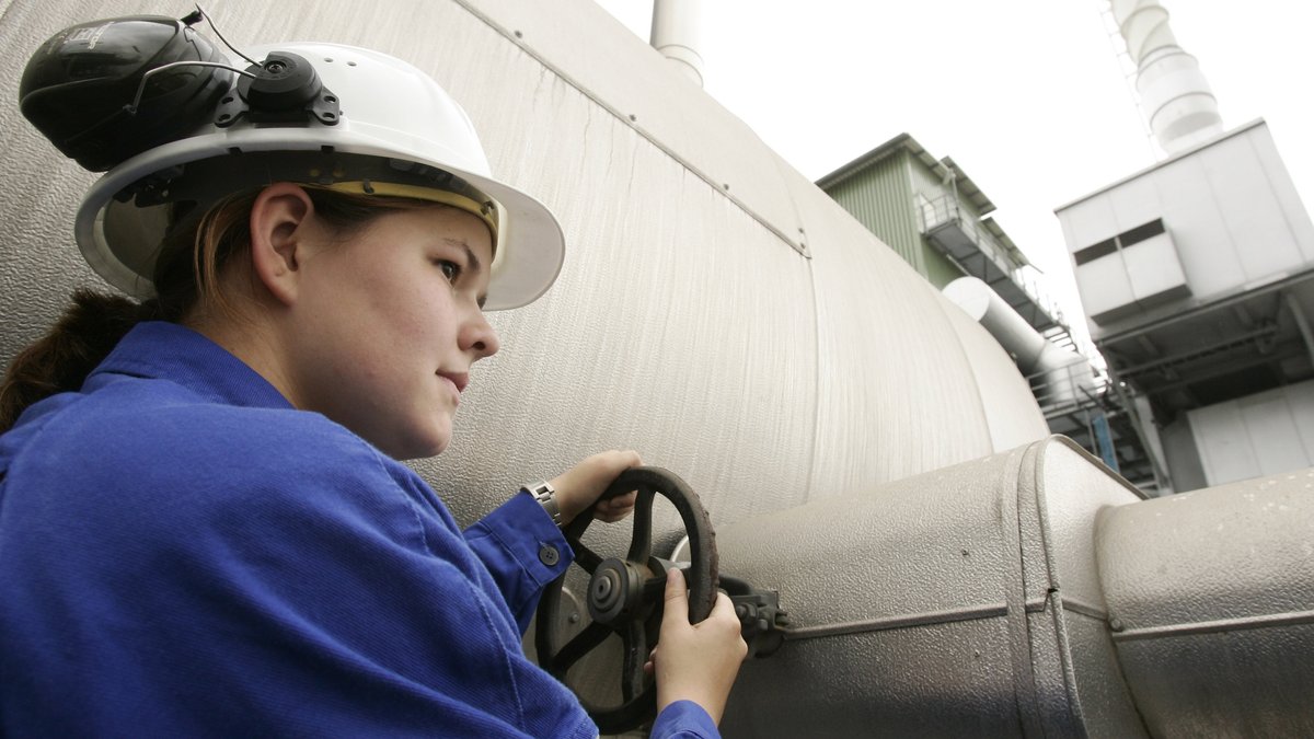 Junge Frau dreht in einem chemischen Unternehmen am Entgaser einer Wasserstoffanlage (Symbolbild).