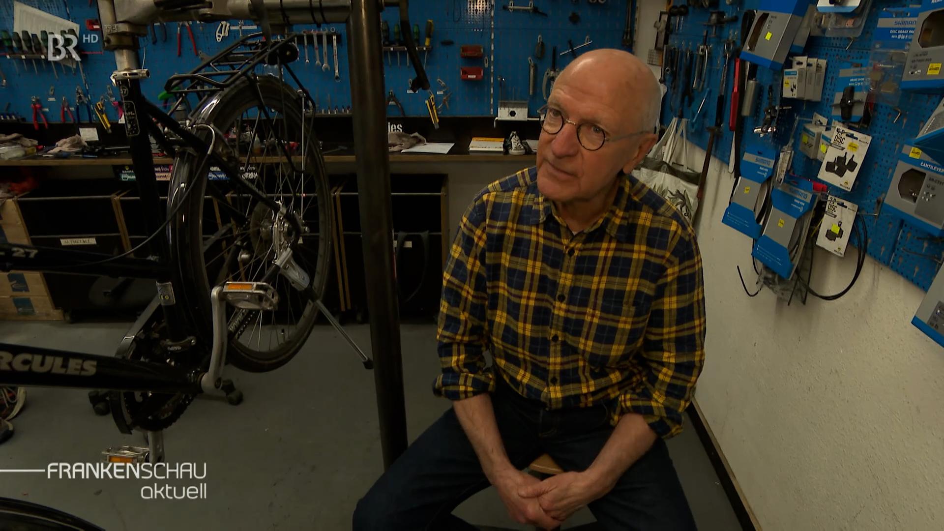 Max Färberböck sitzt in einem Fahrradladen.