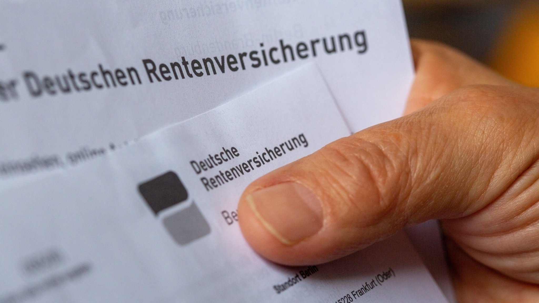 (Symbolbild) Eine Hand hält ein Schreiben der Deutschen Rentenversicherung.