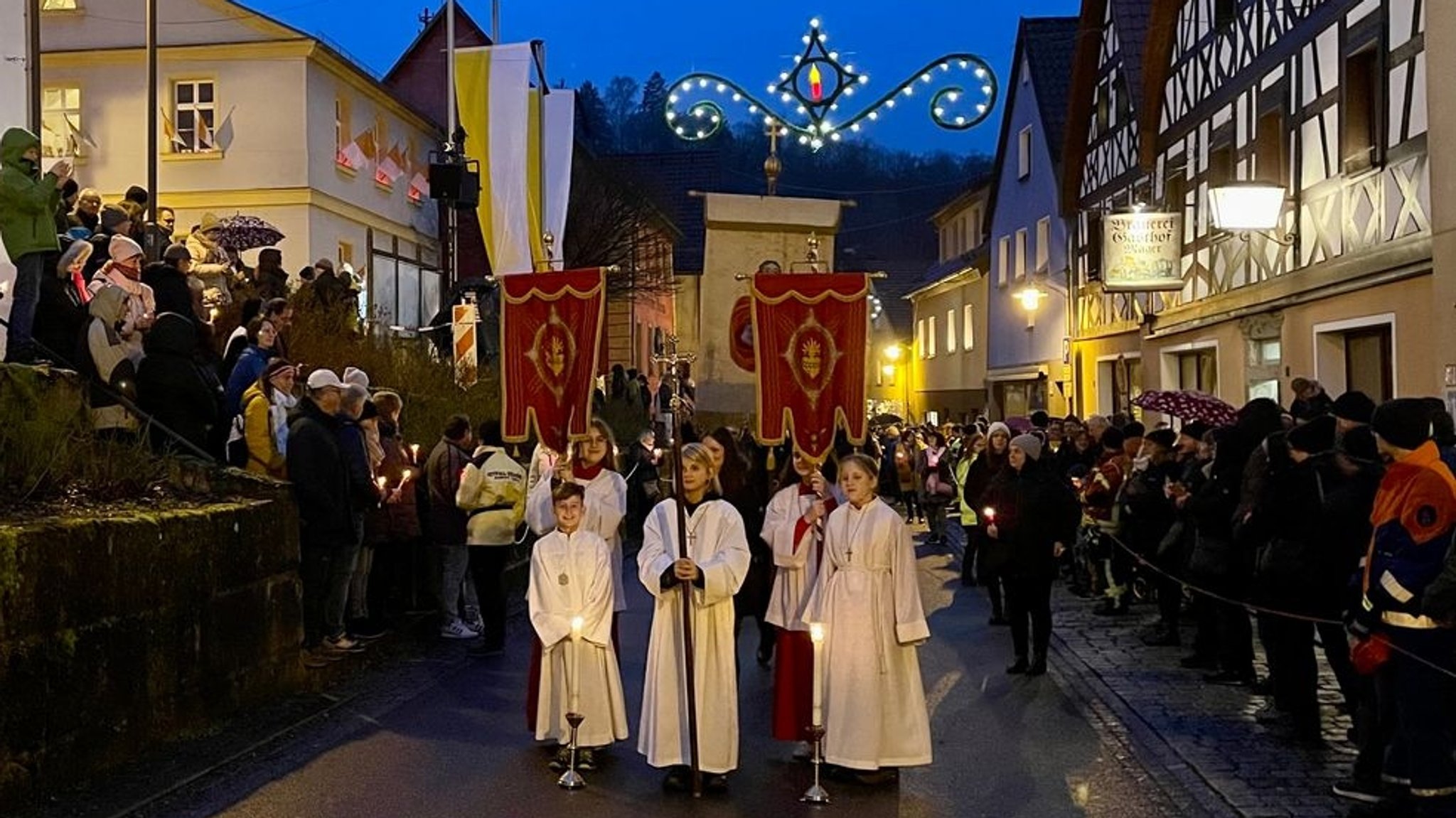 Ministranten führen eine Prozession an.