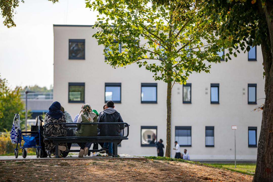 Bewohner des Ankerzentrums in Regensburg  sitzen auf einer Bank (Symbolbild)