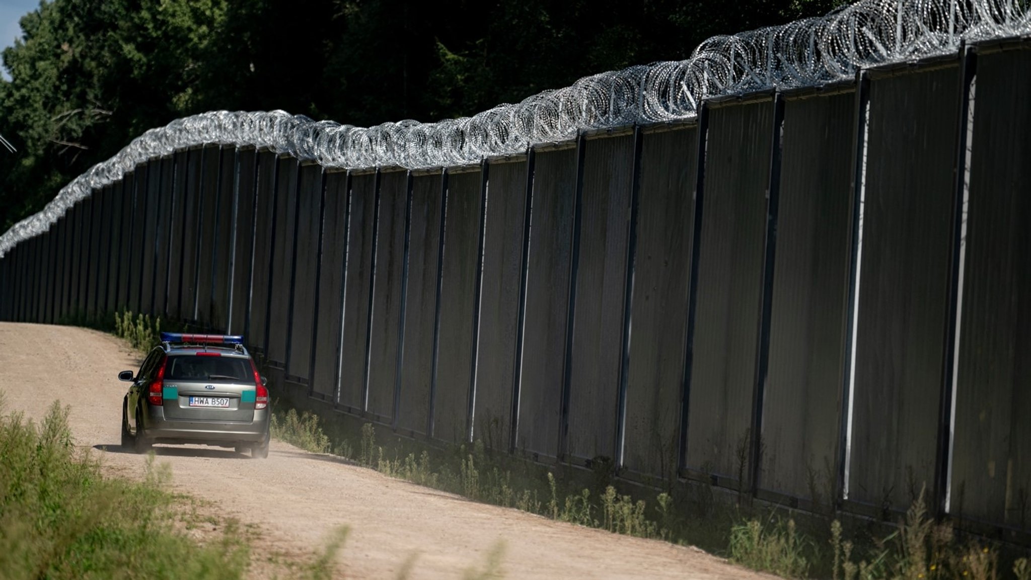 Archivbild (6.9.2023): Ein Fahrzeug der polnische Grenzschützer fährt am Grenzzaun auf der polnischen Seite zu Belarus entlang. An der EU-Außengrenze zum Nachbarland Belarus hat Polen einen 5,5 Meter hohen Metallzaun mit Bewegungsmeldern und Nachtsichtkameras errichtet. 