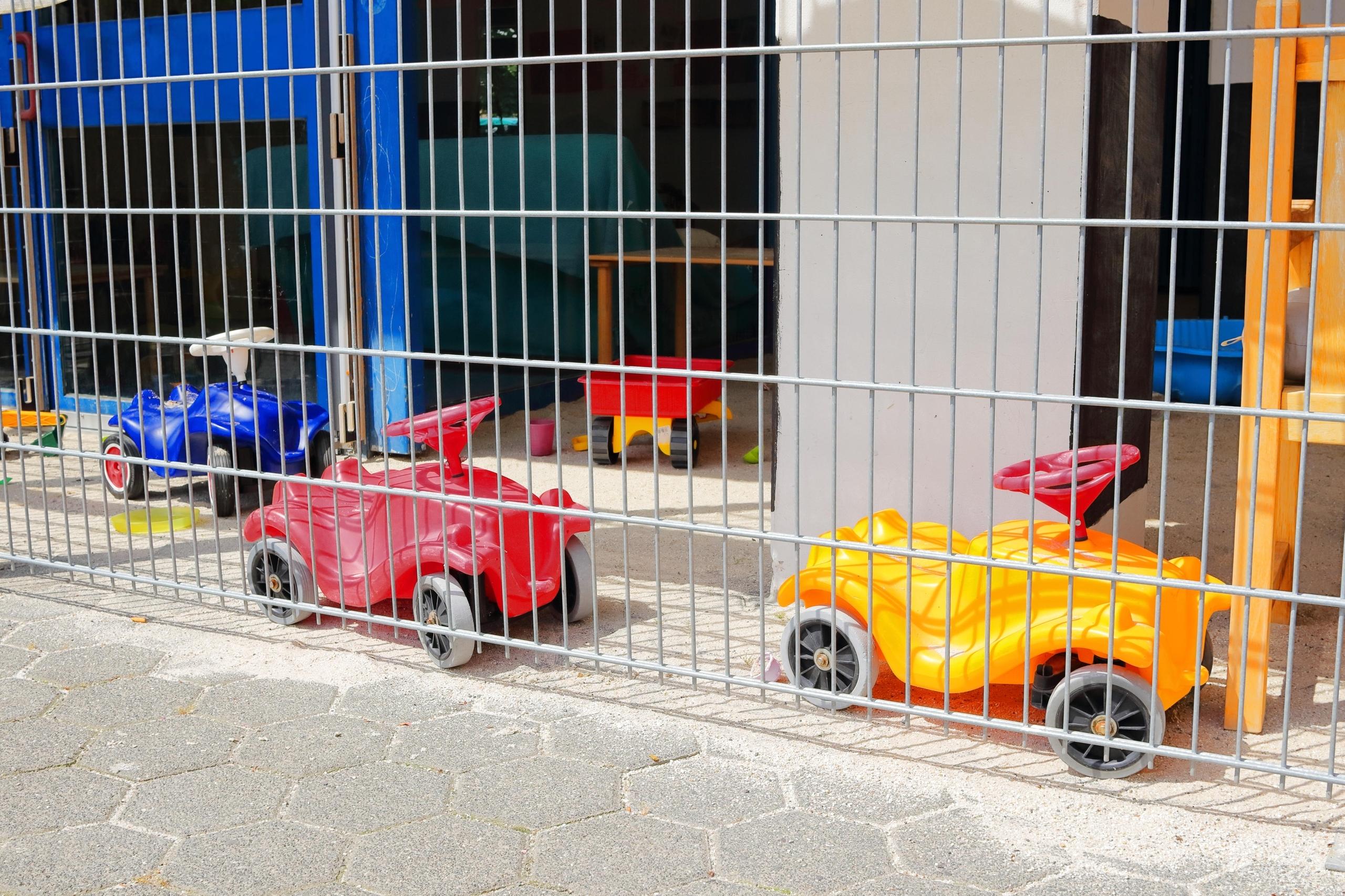 Bobbycars stehen vor einer Kita (Symbolbild)