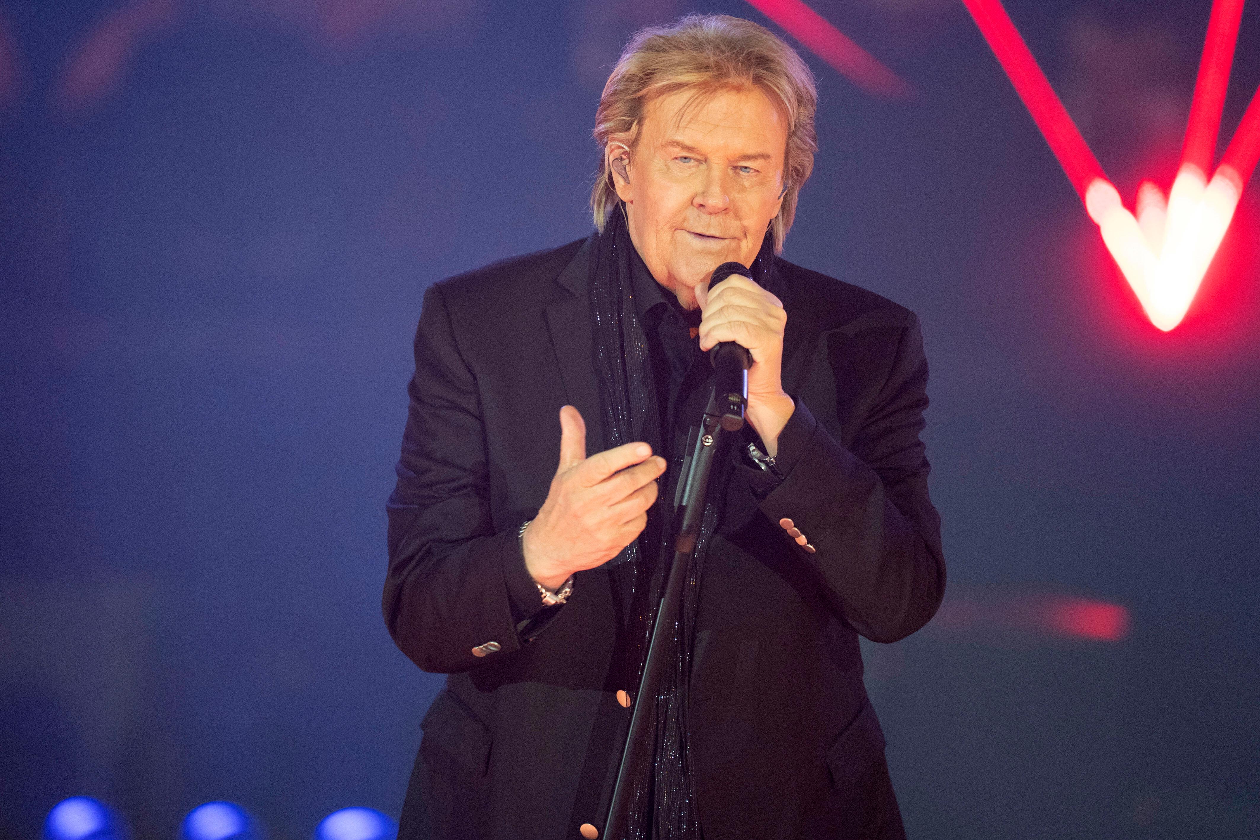Der Sänger performt mit einem Mikro in der Hand