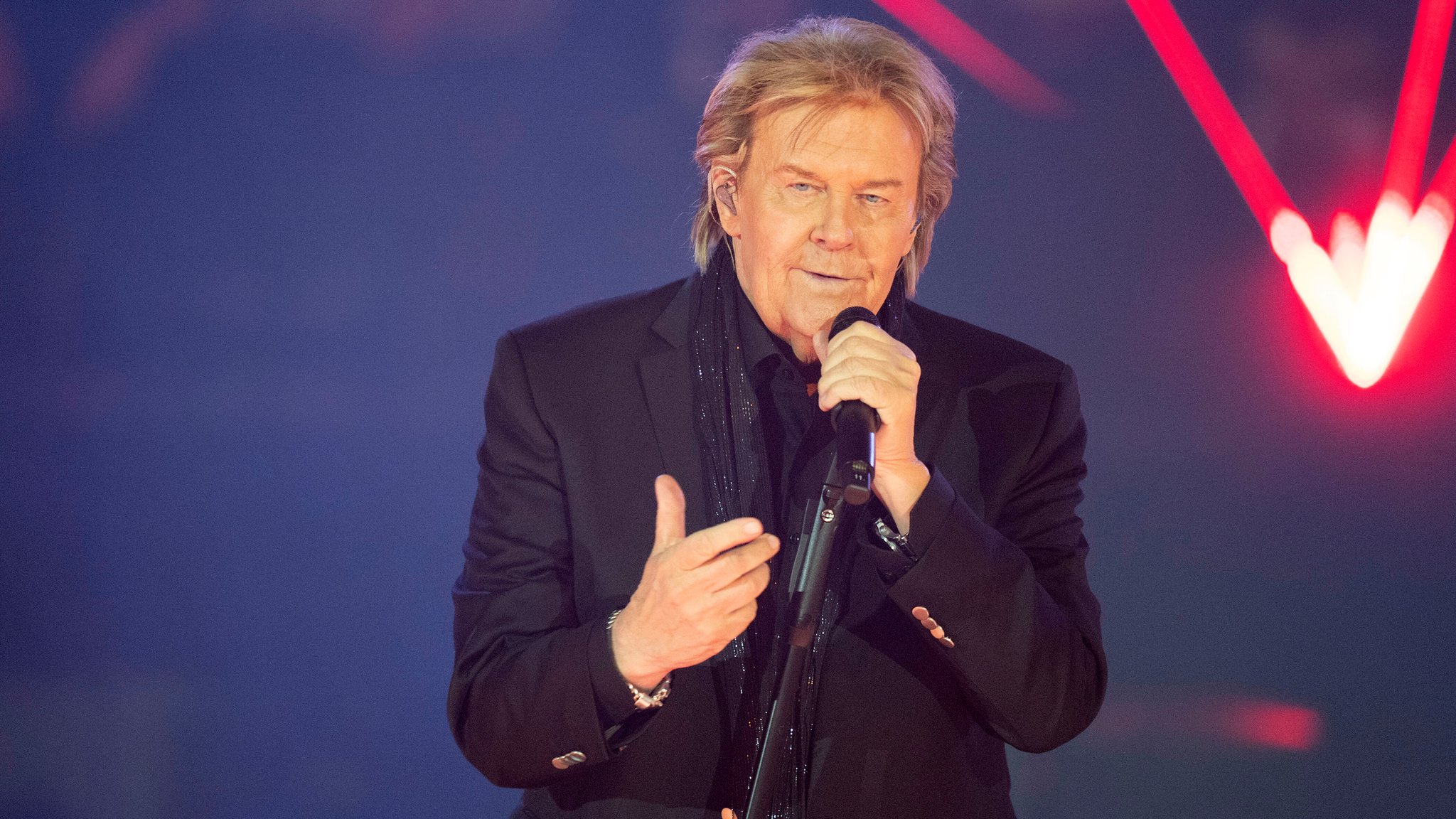 Der Sänger performt mit einem Mikro in der Hand