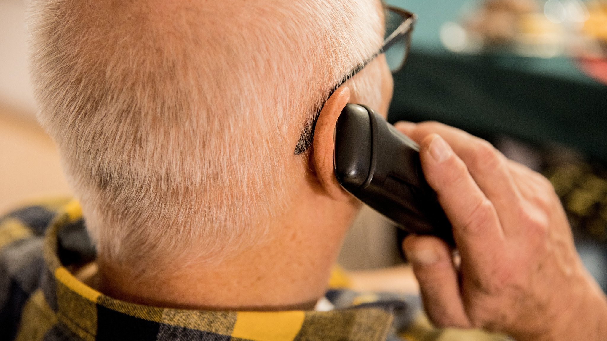 Ein älterer Mann telefoniert mit einem mobilen Telefon. 