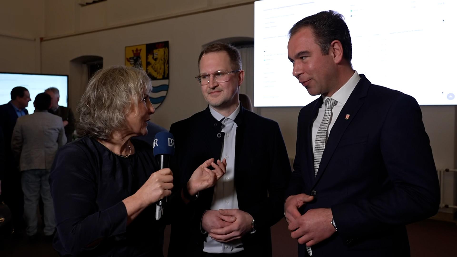 BR-Reporterin Susanne Pfaller mit den Neuburger Kandidaten der Stichwahl Gerhard Schoder (Grüne) und Matthias Enghuber (CSU).