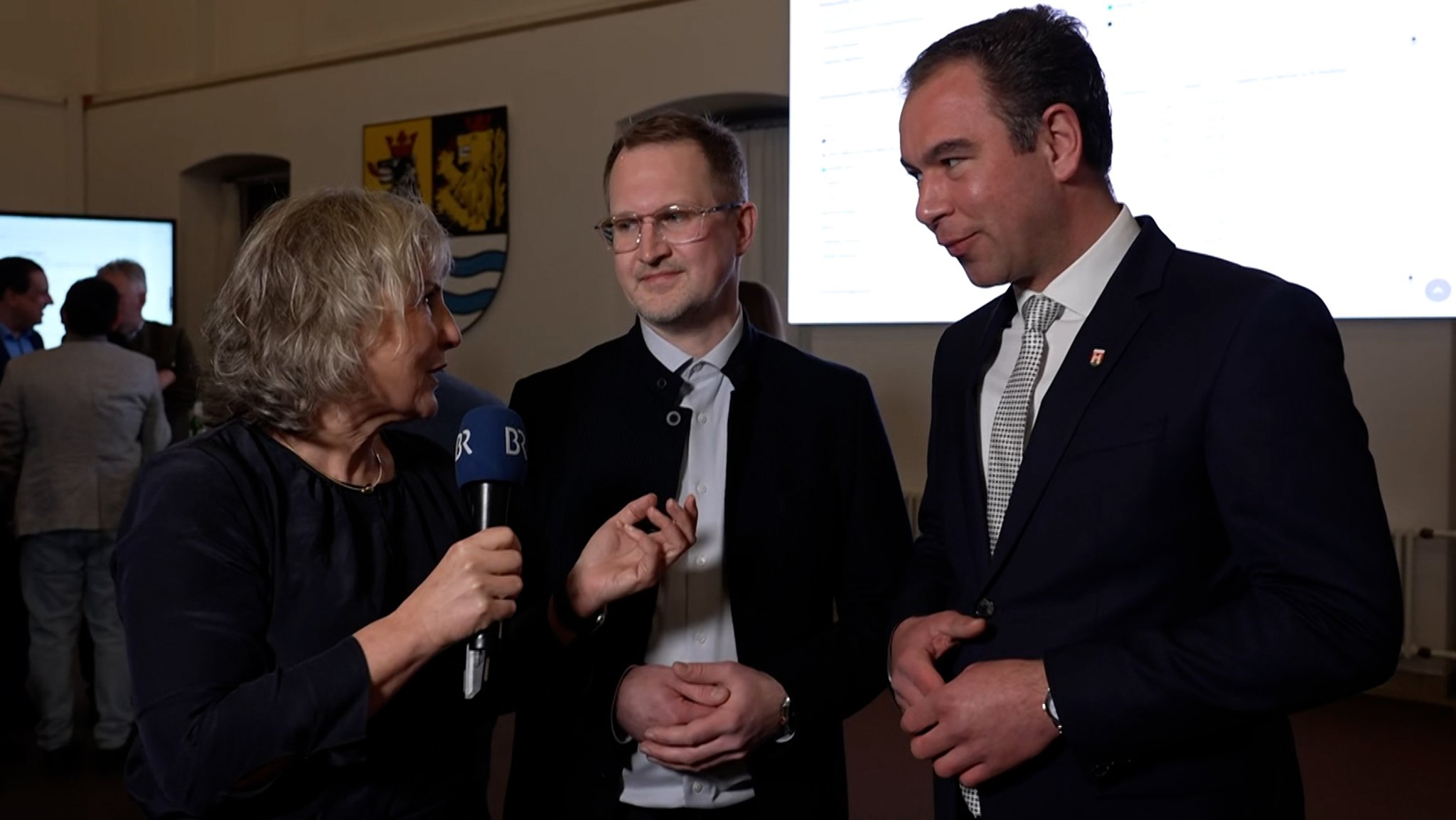BR-Reporterin Susanne Pfaller mit den Neuburger Kandidaten der Stichwahl Gerhard Schoder (Grüne) und Matthias Enghuber (CSU).
