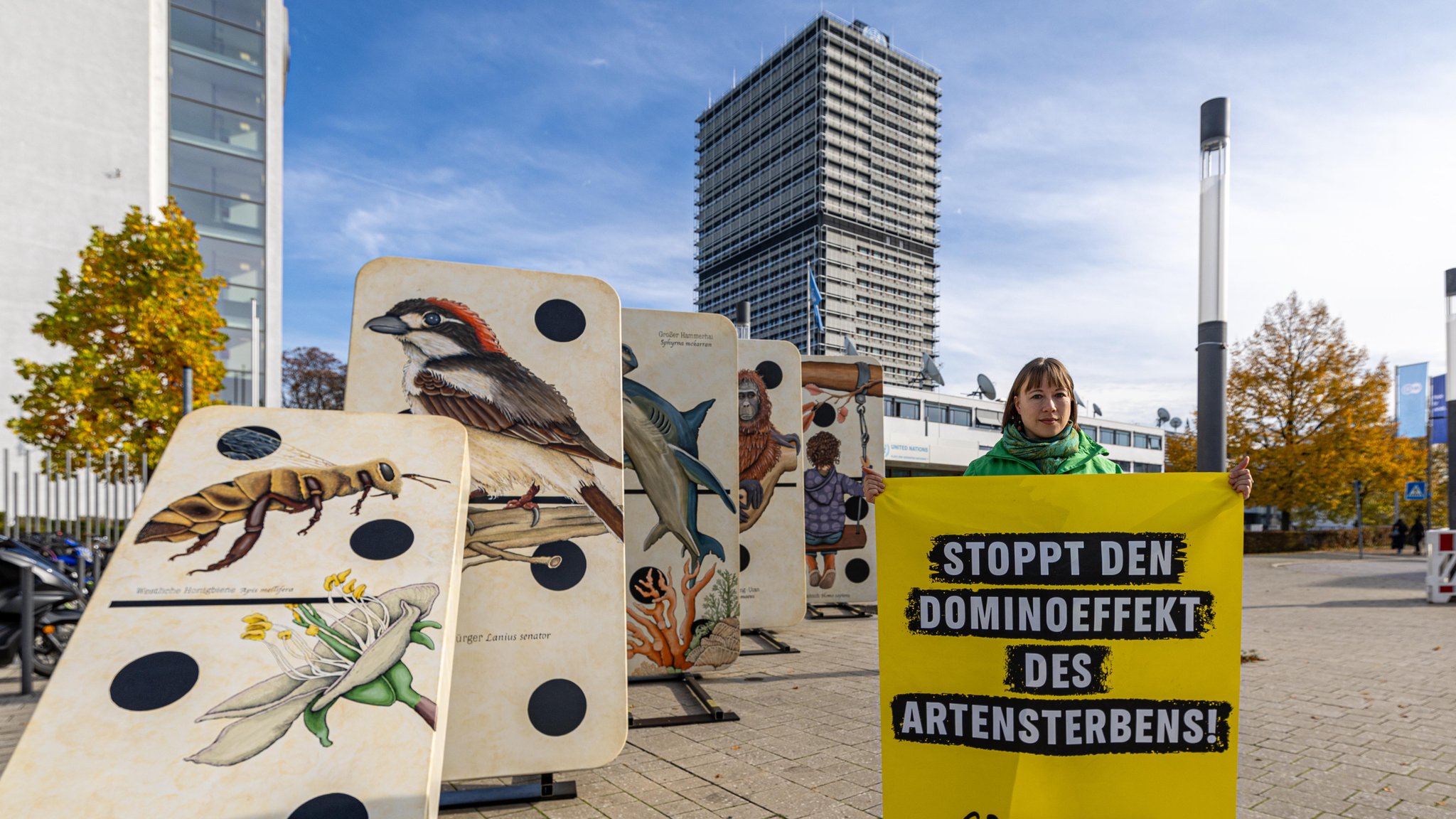 Wenige Tage vor Beginn COP16 demonstrieren Aktivisten auf dem Platz der Vereinten Nationen in Bonn mit der Aktion "Stoppt den Dominoeffekt des Artensterbens"