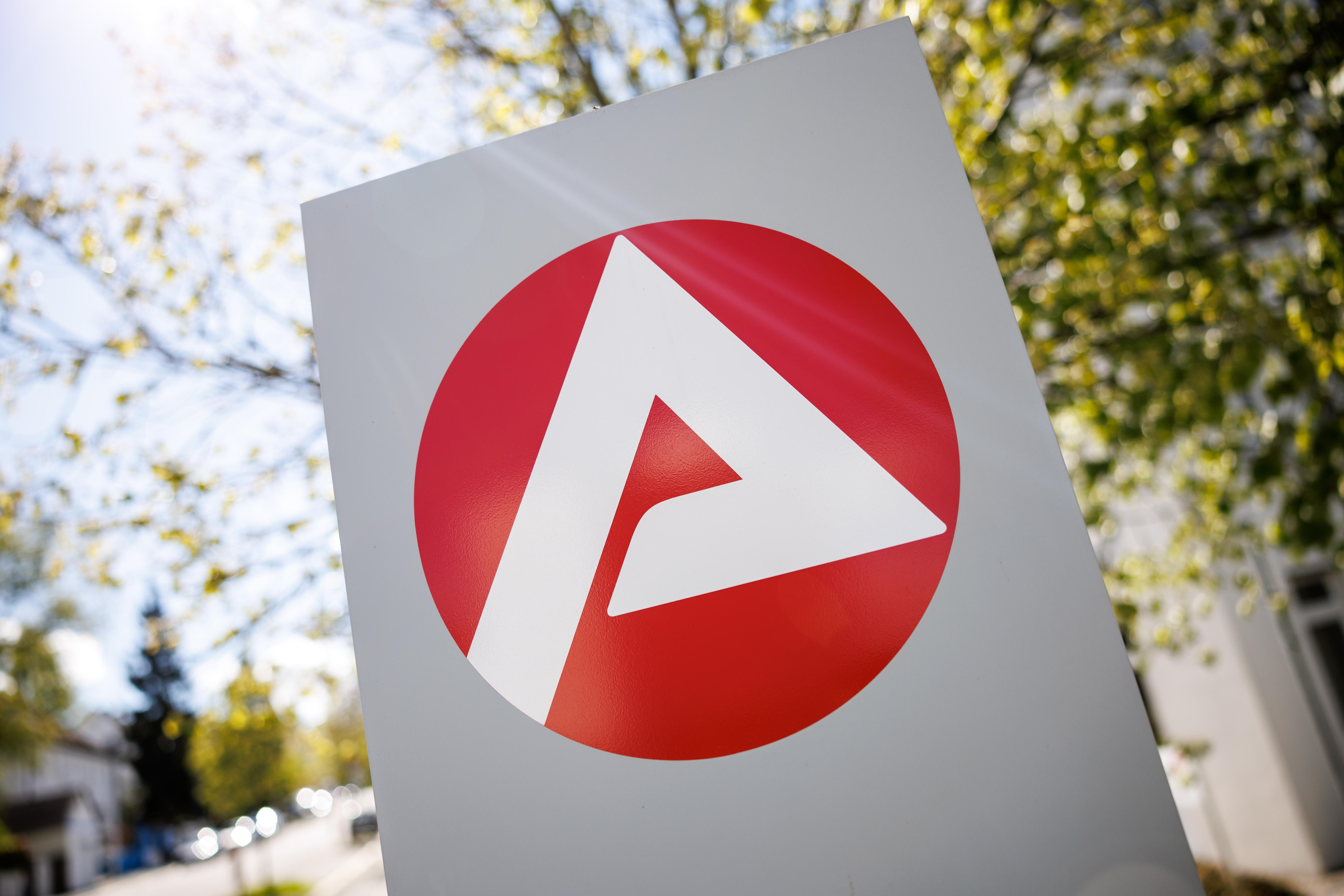 Logo der Agentur für Arbeit an einer Stele vor einem Behördengebäude der Agentur für Arbeit