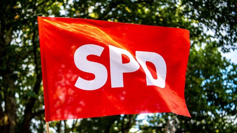 Eine SPD-Fahne weht vor grünen Bäumen (Symbolbild)