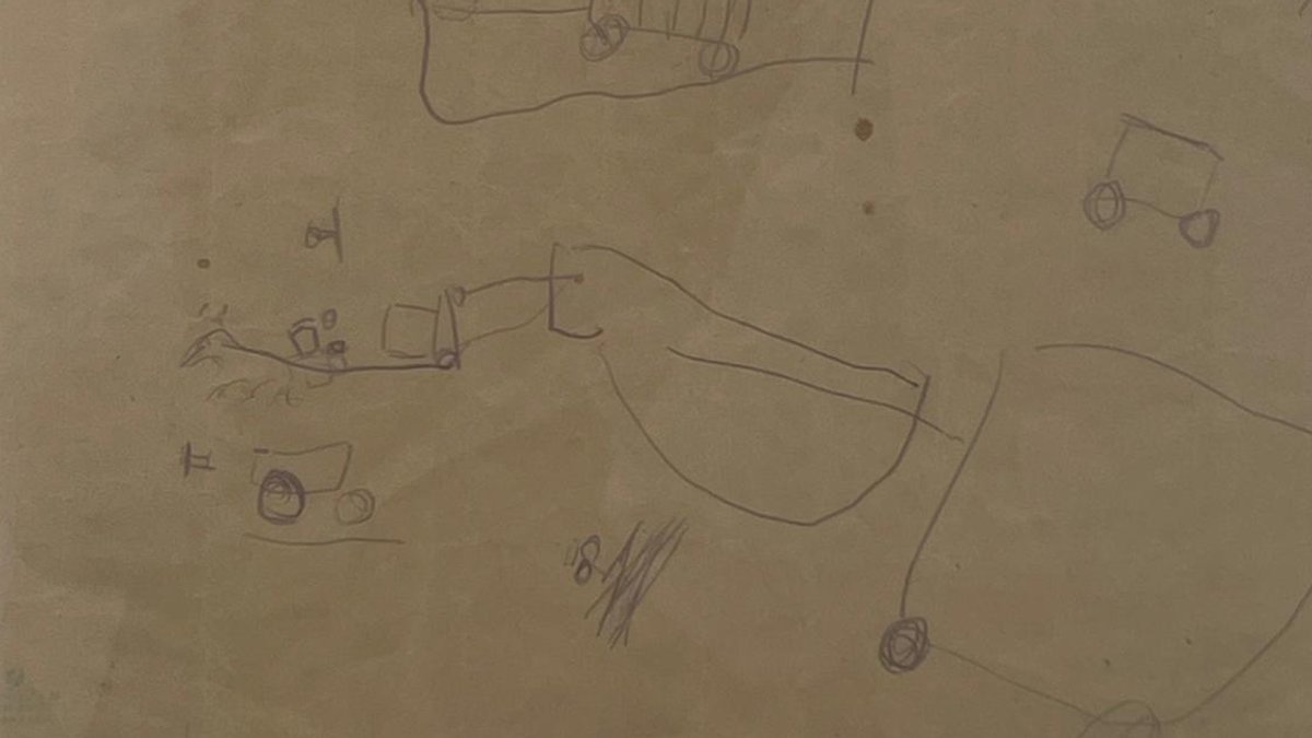 Bleistiftzeichnung des etwa zwei Jahre alten Fritz. Kein Gekritzel, sondern eine Zeichnung, auf der schon Wagen zu erkennen sind.