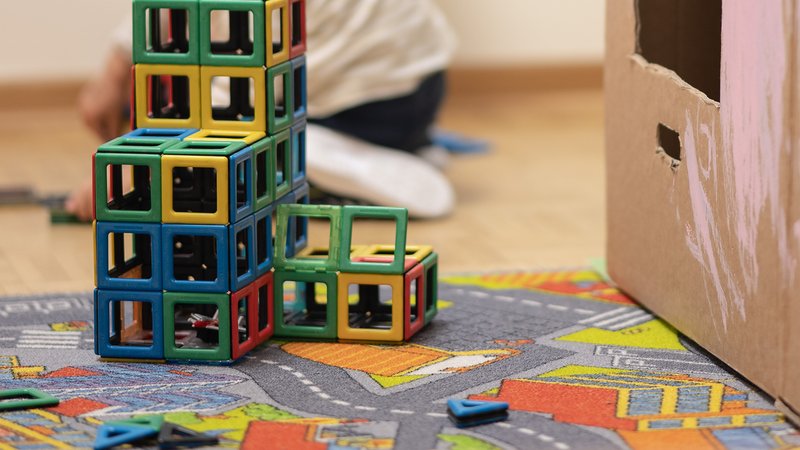 Spielzeug steht in einer Kita auf einem Spielzeugteppich (Symbolbild).