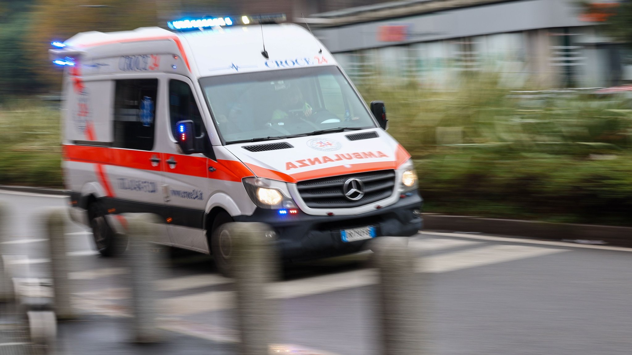 Foto: Ein italienischer Rettungswagen mit der Aufschrift "Ambulanza" fährt mit Blaulicht durch eine verregnete Straße. Der Hintergrund ist verwischt. | Bild: dpa-Bildfunk/Jan Woitas Foto: Ein italienischer Rettungswagen mit der Aufschrift "Ambulanza" fährt mit Blaulicht durch eine verregnete Straße. Der Hintergrund ist verwischt.
