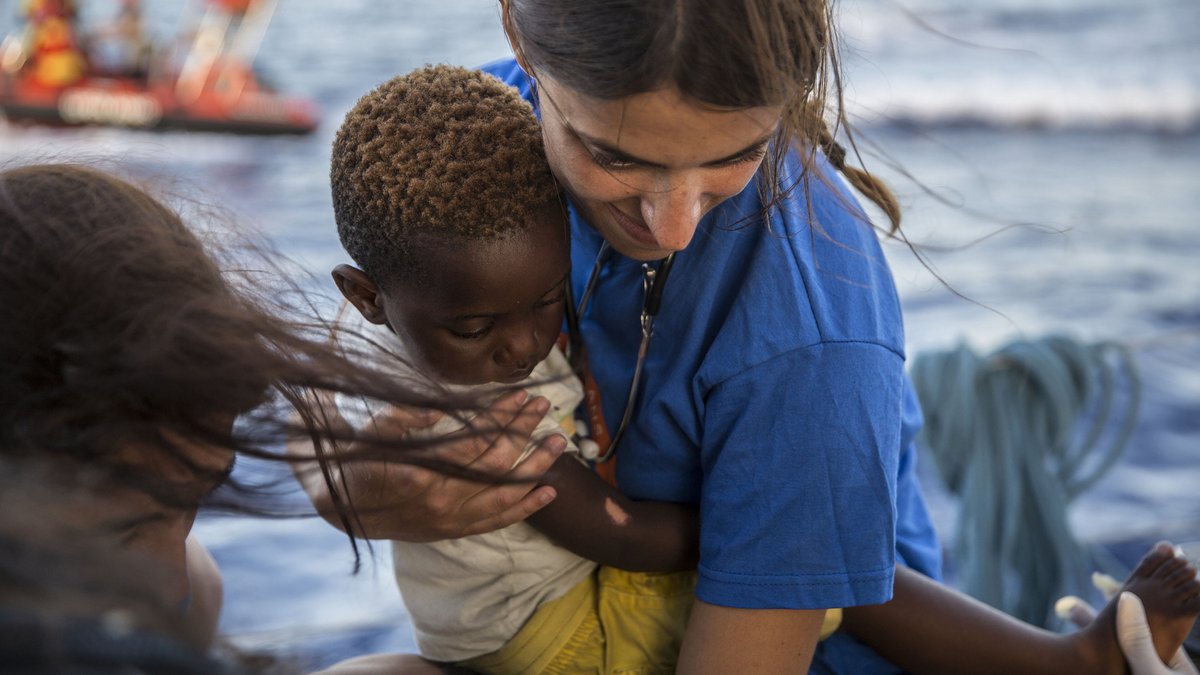 Im Mittelmeer hält am 4. Juli eine Mitarbeiterin der Hilfsorganisation Mediterranea Saving Humans einen kleinen Jungen im Arm.