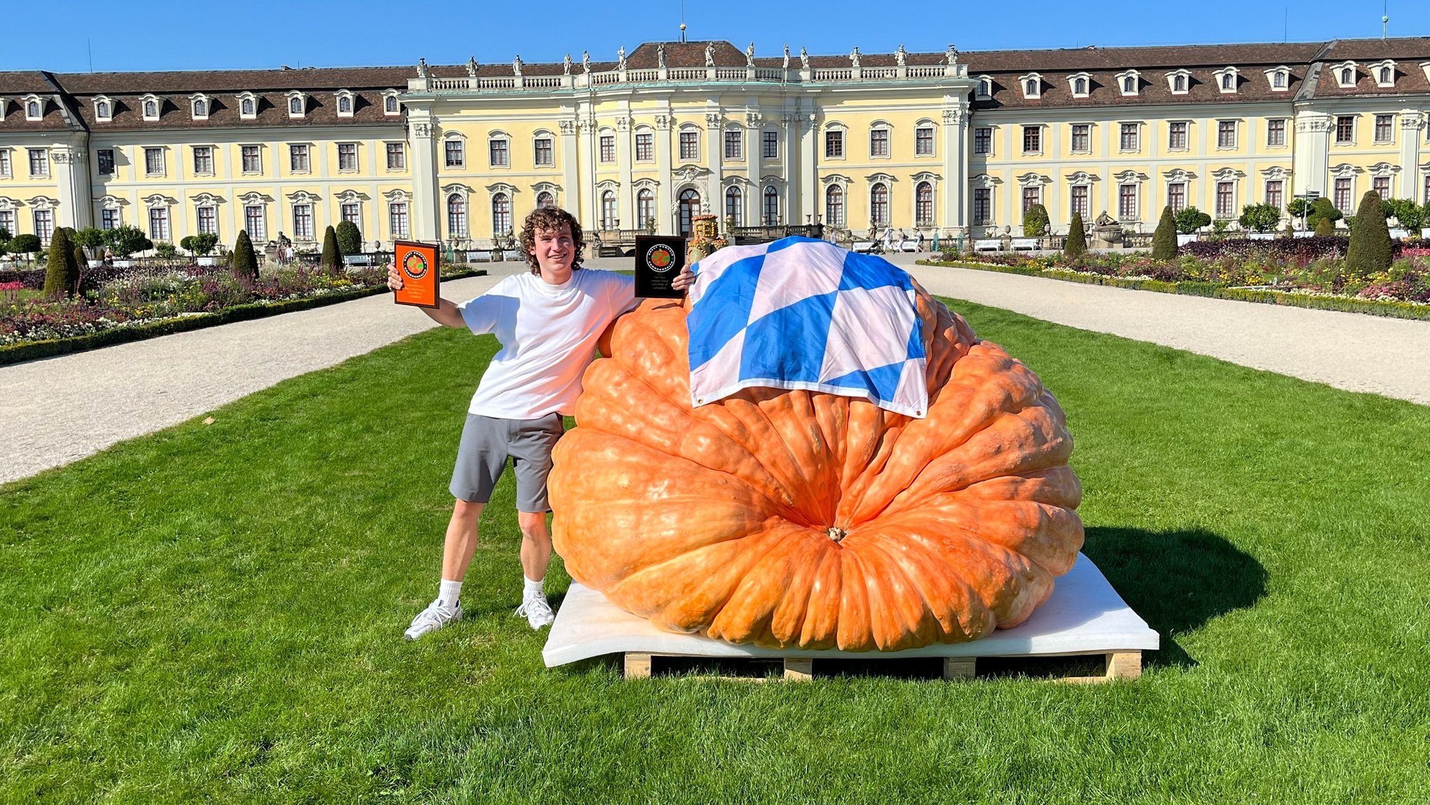 Kürbis-Züchter Luca Stöckl steht neben seinem Riesenkürbis.