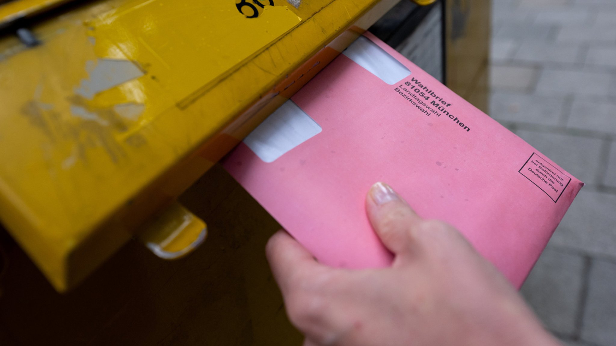 Eine Frau wirft bei einer früheren Wahl einen Wahlbrief in einen Postkasten