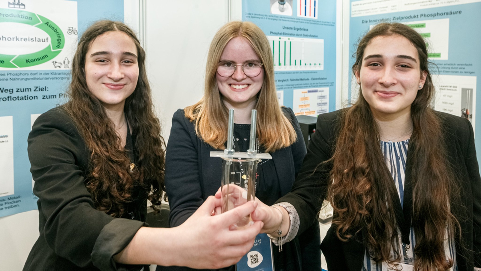 Die Chemie-Bundessiegerinnen von Jugend forscht: Lena Fries, Hannah Amrhein und Hanna Fries aus Bayern mit einem Becherglas mit Elektroden.