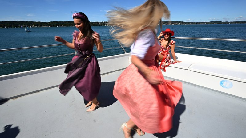 Die Models Rebecca Fiedler (l) und Nicole Böttinger tanzen bei einer Trachtenmoden-Fahrt mit dem Schiff "Seeshaupt" der Bayerischen Seenschifffahrt über den Starnberger See. | Bild: dpa-Bildfunk/Felix Hörhager Die Models Rebecca Fiedler (l) und Nicole Böttinger tanzen bei einer Trachtenmoden-Fahrt mit dem Schiff "Seeshaupt" der Bayerischen Seenschifffahrt über den Starnberger See.