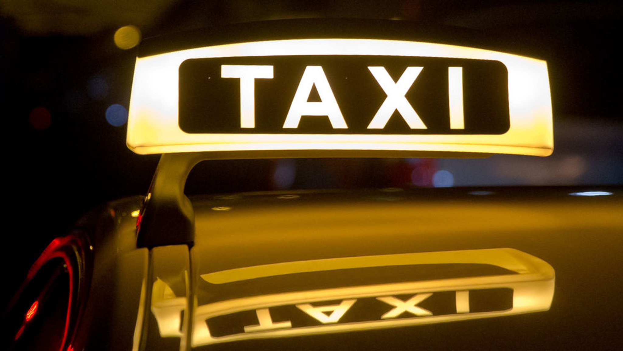 Ein beleuchtetes Taxi-Schild auf einem Autodach. (Symbolbild) | Bild: dpa-Bildfunk/Daniel Karmann Ein beleuchtetes Taxi-Schild auf einem Autodach. (Symbolbild)