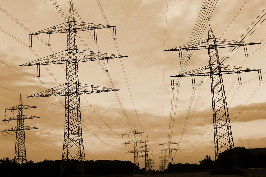 Überlandleitungen vor düsterem Himmel.