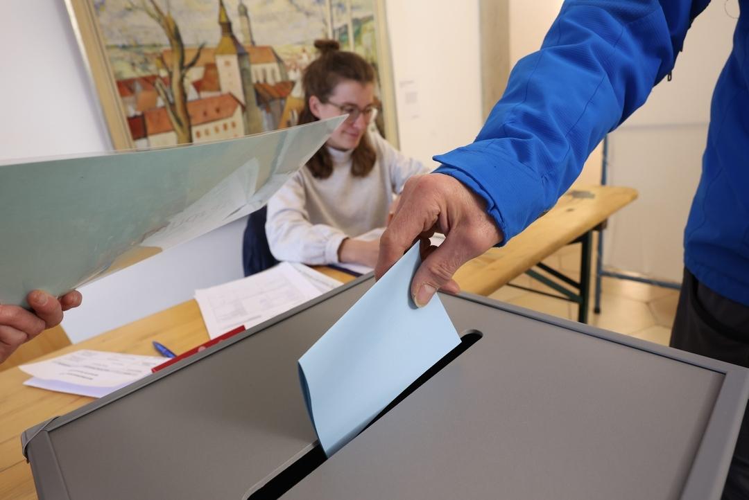 22.03.2026, Bayern, Landsberg am Lech: Ein Wähler wirft bei der Stichwahl zur Landratswahl im Rathaus seinen Stimmzettel in eine Wahlurne. 