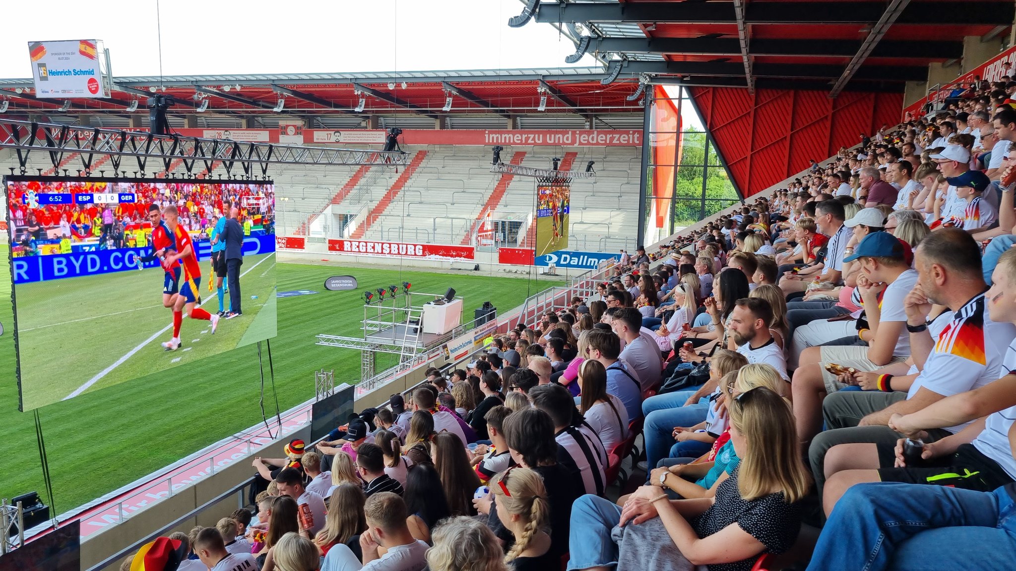 Fußballfans schauen auf einer Leinwand im Regensburger Jahn-Stadion das EM-Spiel Deutschland-Spanien.