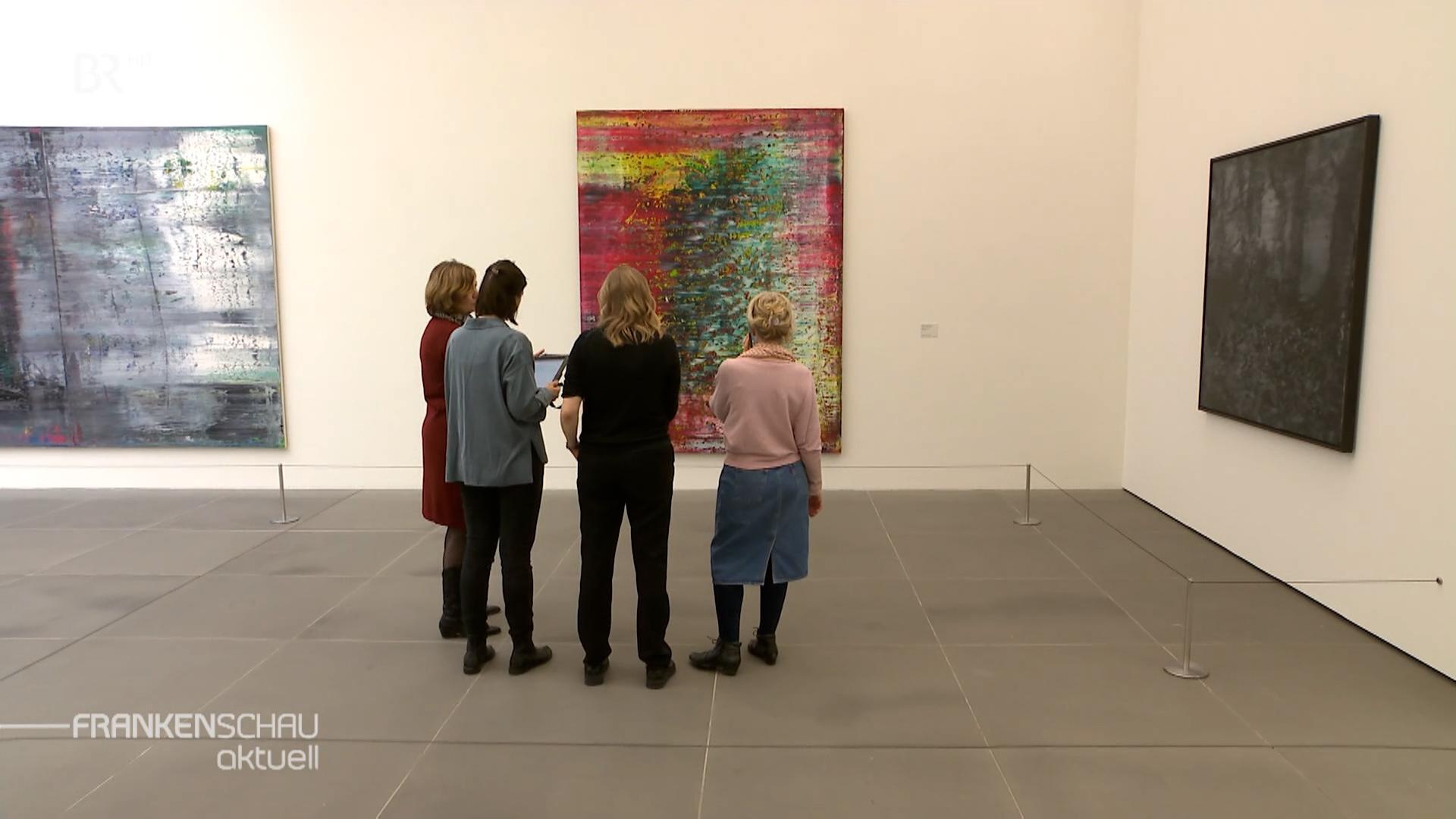 Frauen schauen sich Bilder in der Gerhard Richter Kunstausstellung Nürnberg an.