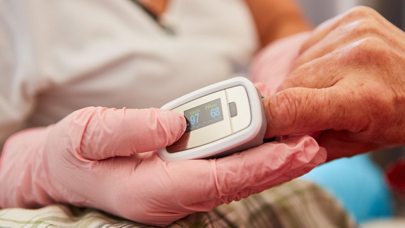 Pulsoximeter am Finger einer Patientin zur Messung von Puls und Sauerstoffsättigung