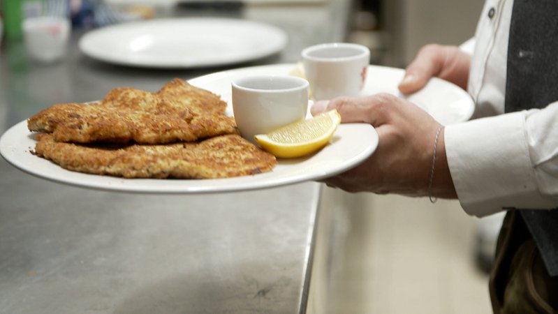 Person trägt zwei Teller mit Wiener Schnitzel | Bild: BR Person trägt zwei Teller mit Wiener Schnitzel