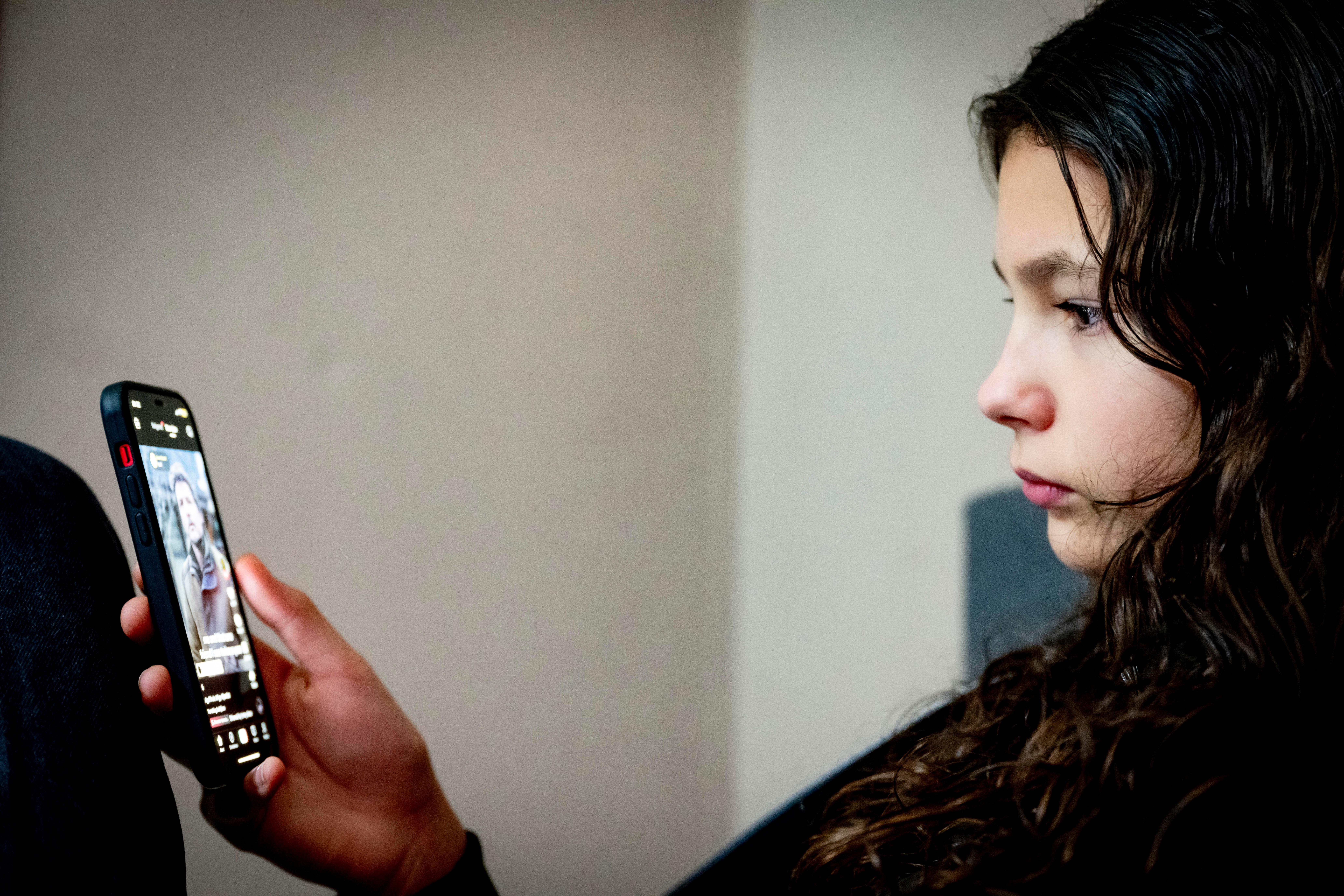 Ein Mädchen schaut ein Video auf TikTok an (Symbolbild)