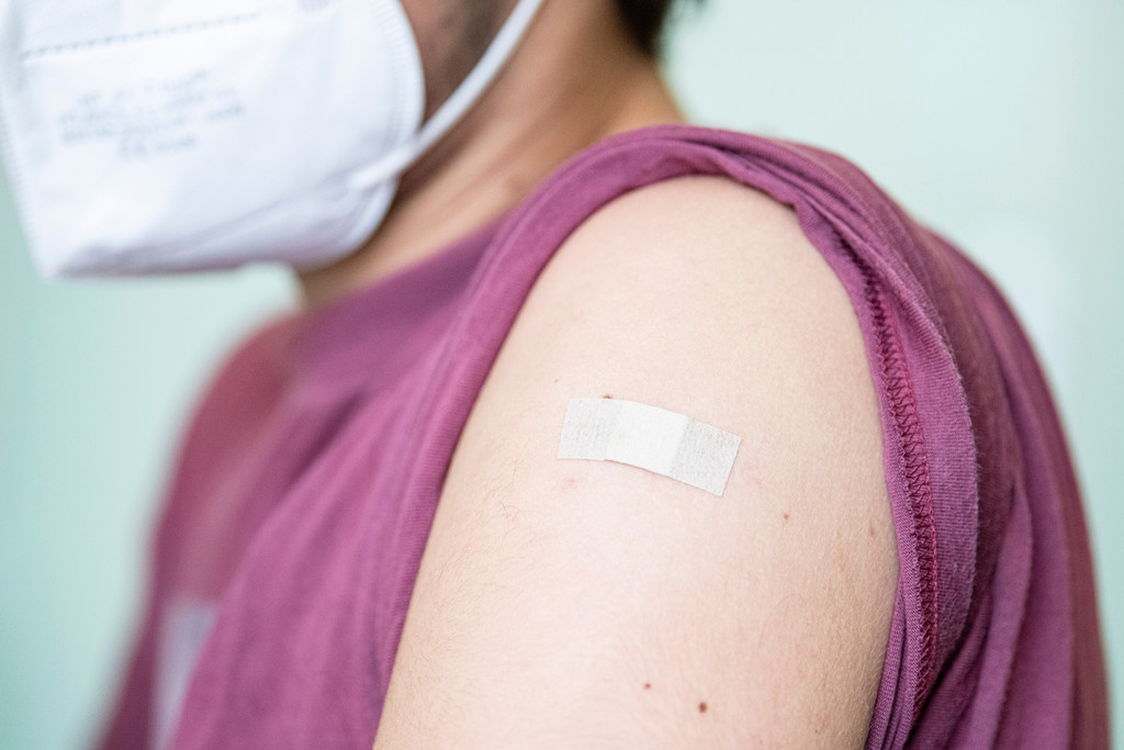 Pflaster klebt nach einer Corona-Impfung auf einem Arm