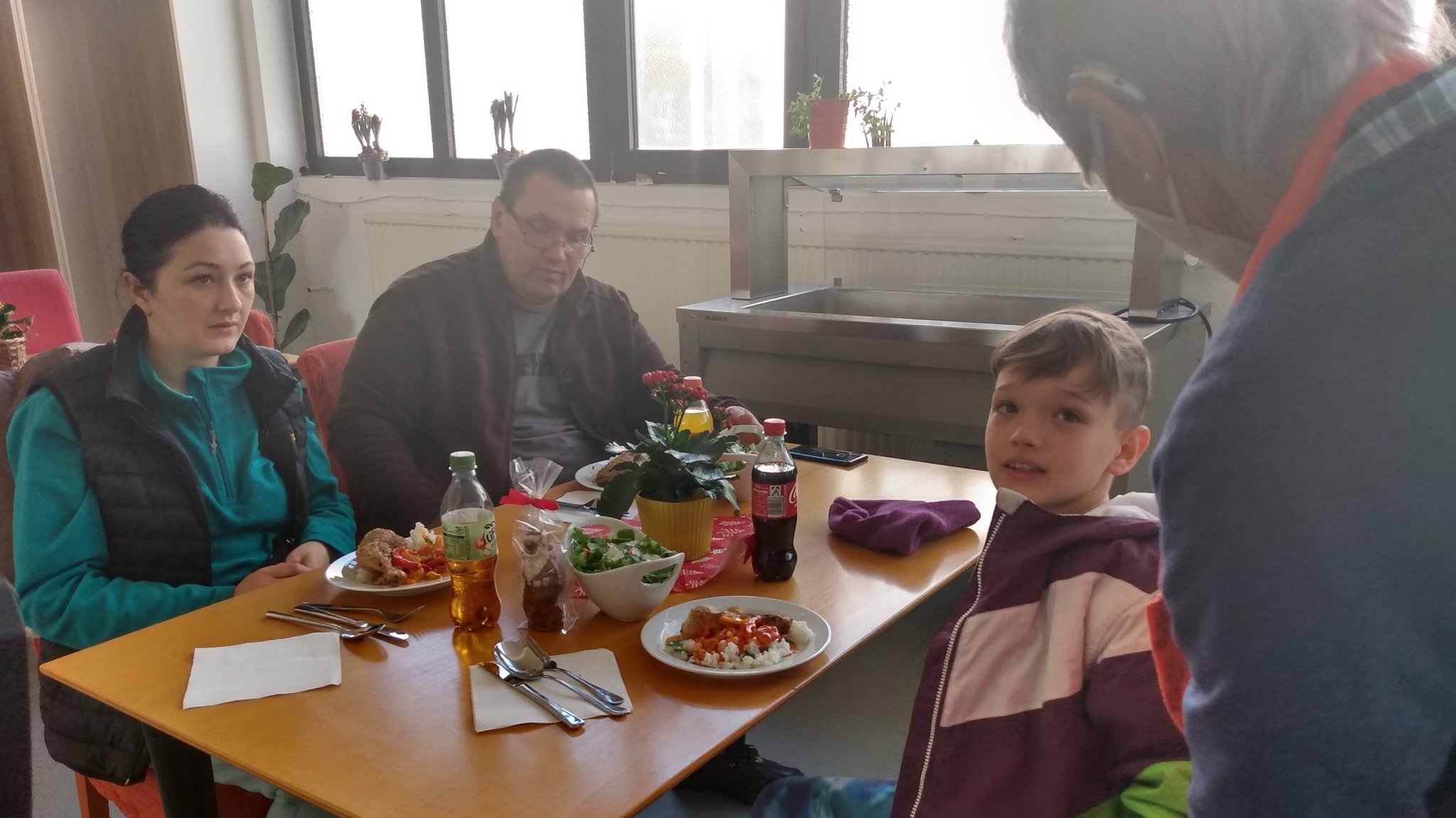 Vater, Mutter und Sohn an einem Tisch beim Mittagessen.