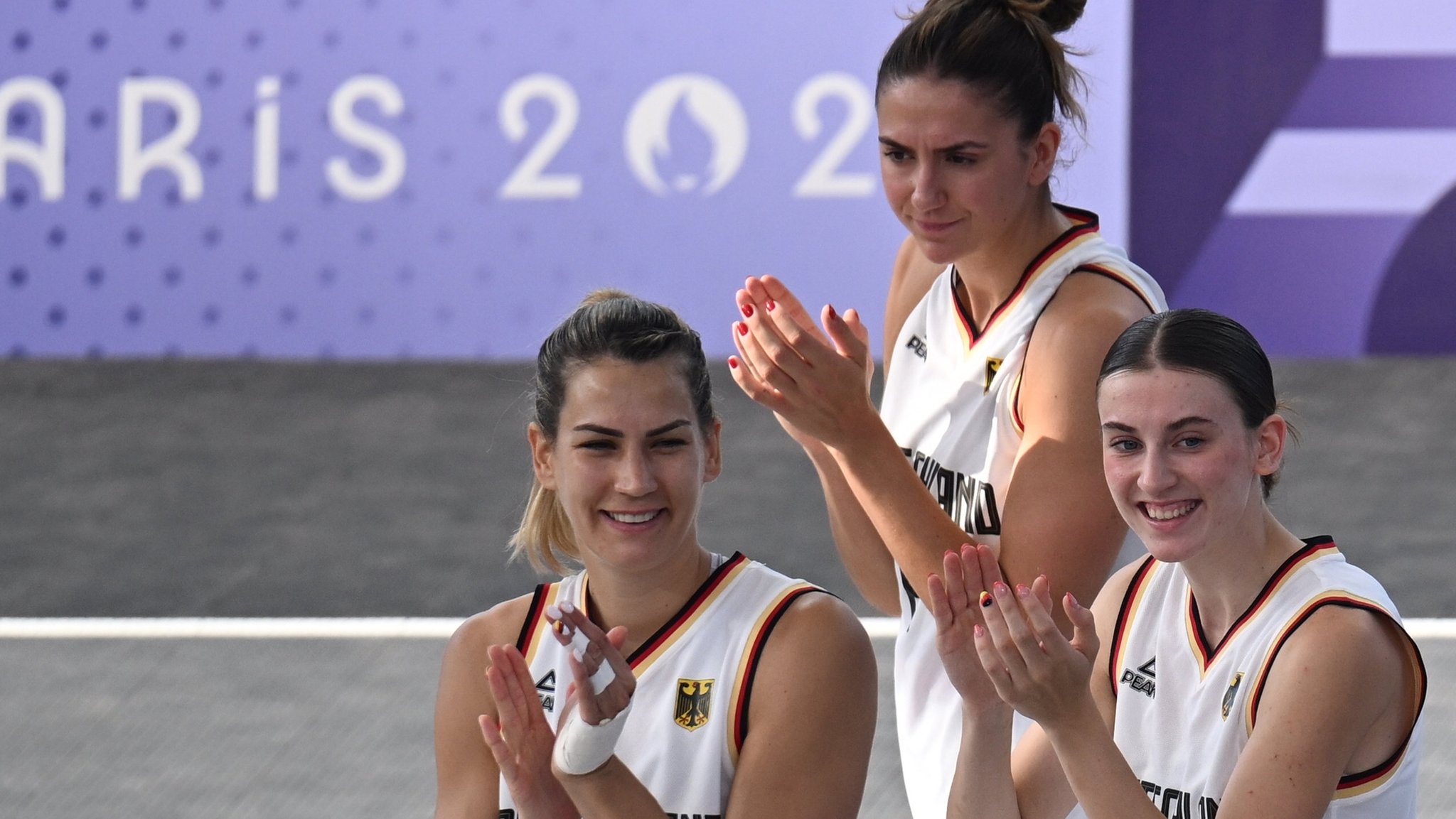 Spielerinnen Sonja Greinacher (l-r), Marie Reichert und Elisa Mevius applaudieren den Fans.