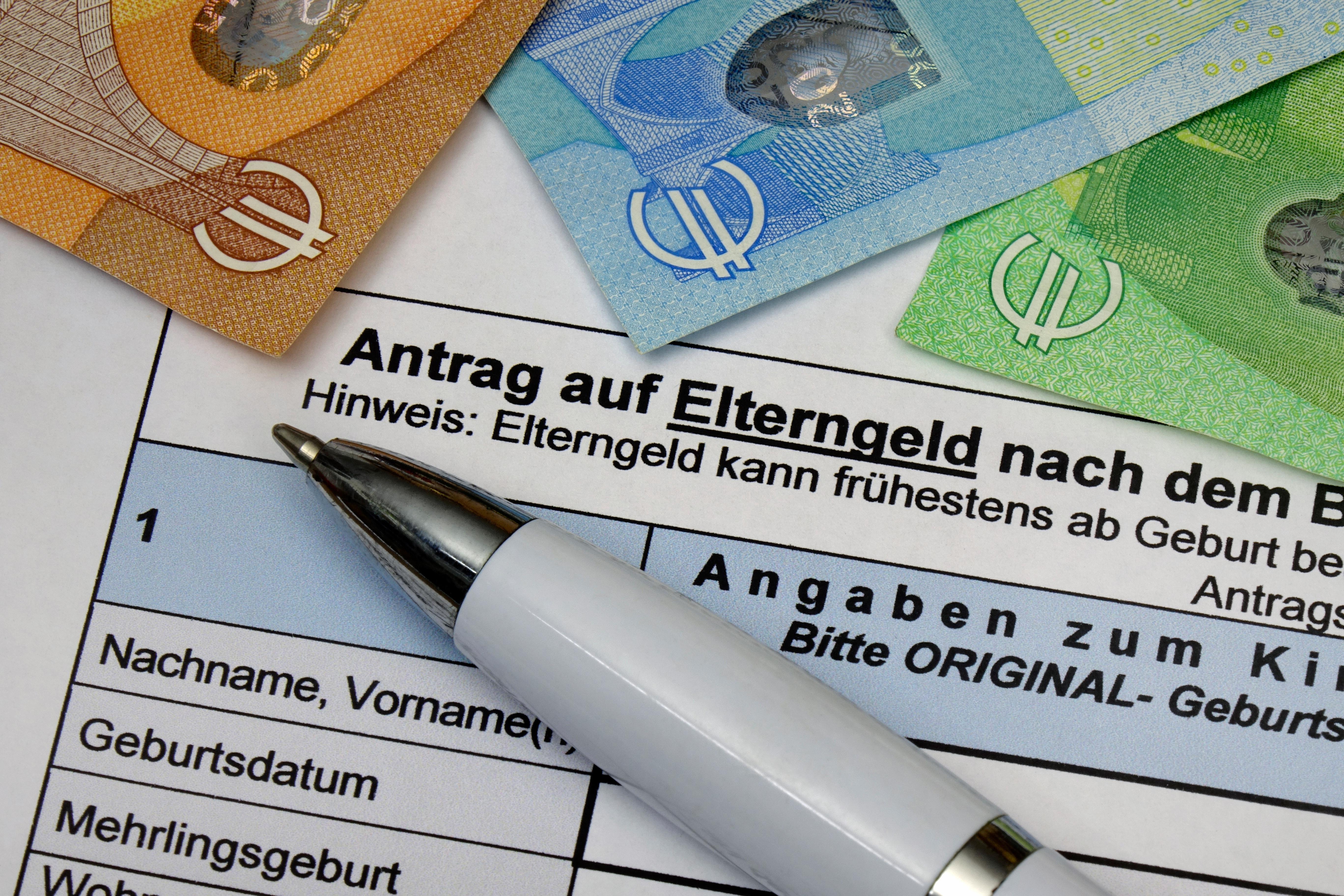 ARCHIV (05.02.2023): Auf einem Antrag auf Elterngeld liegen Geldscheine und ein Kugelschreiber.