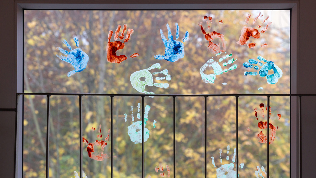 Farbige Abdrücke von Kinderhänden auf einem Kita-Fenster