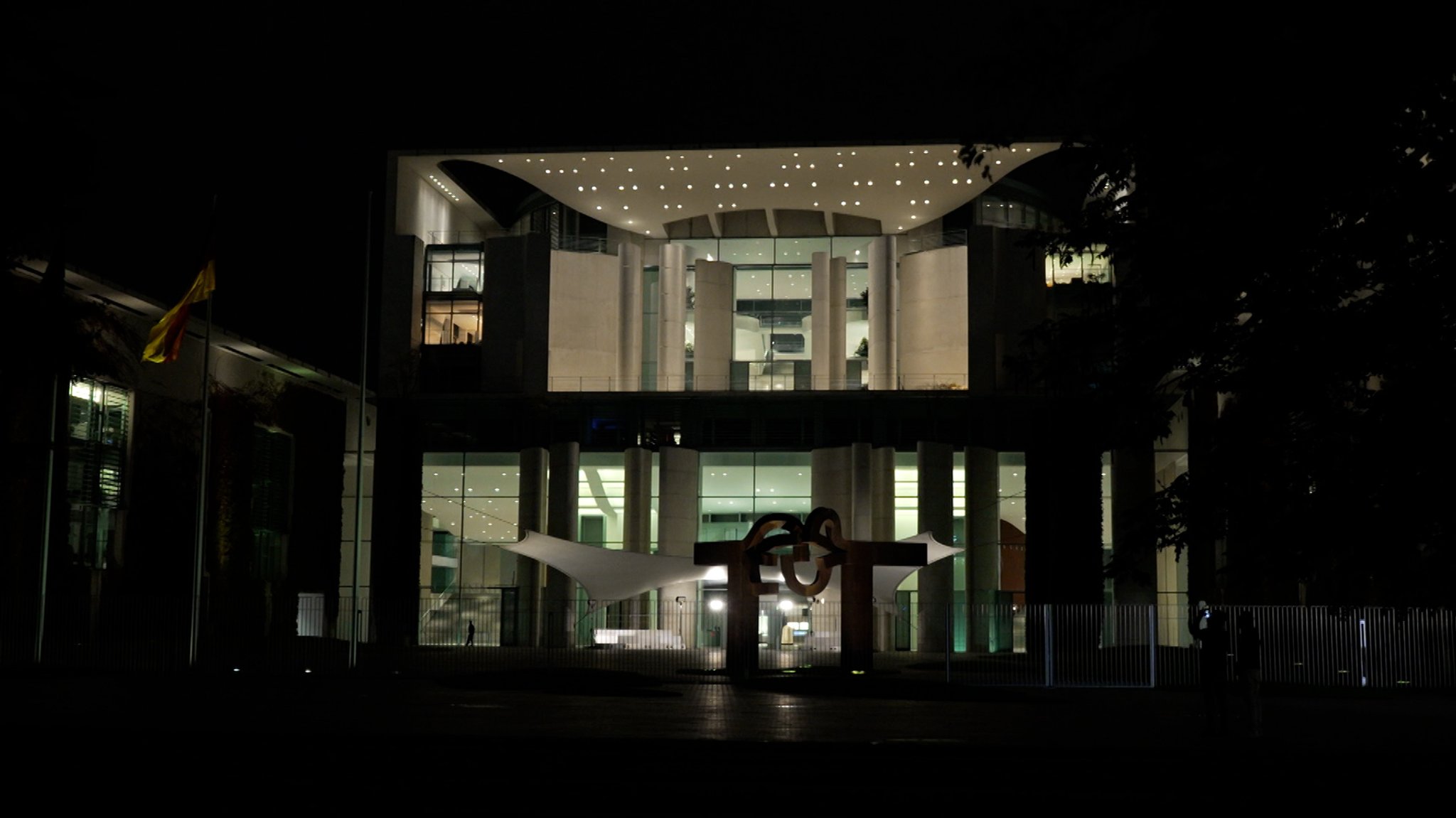 Blick auf das hell erleuchtete Bundeskanzleramt in Berlin bei Nacht.