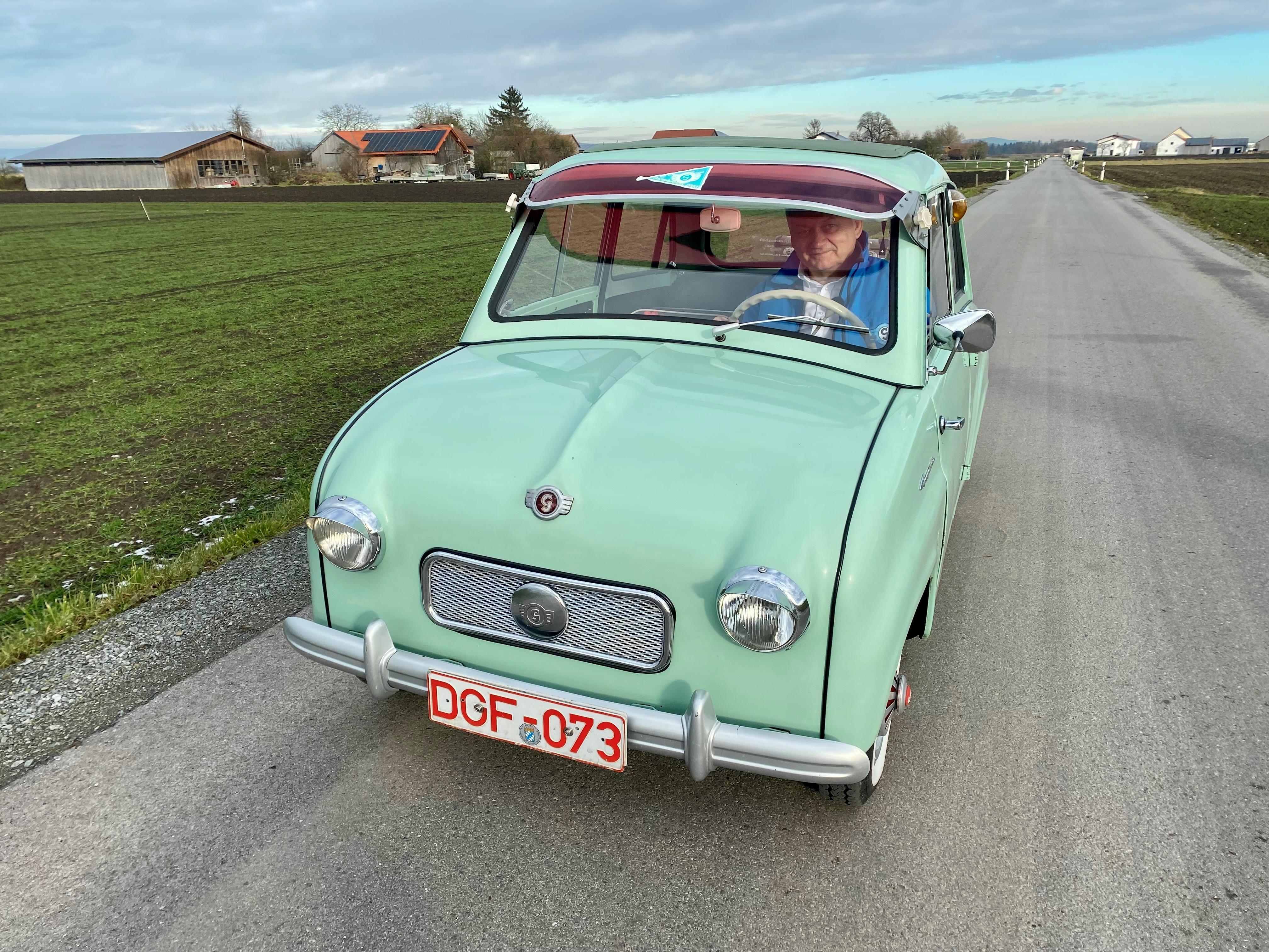 Ein kleines Auto mit türkisem Lack